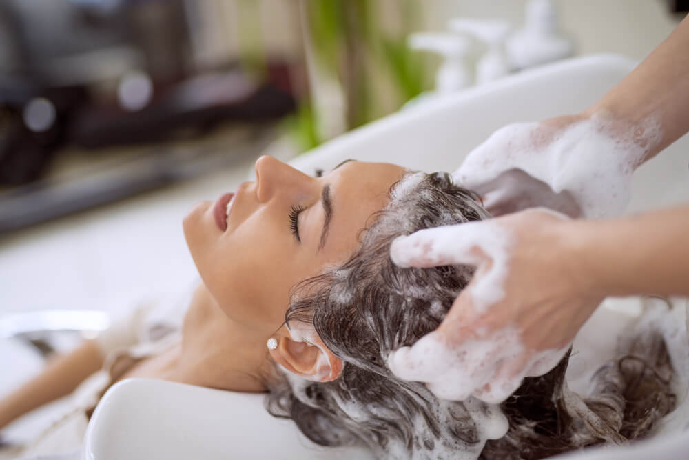 A woman gets a shampoo treatment at a hair salon.